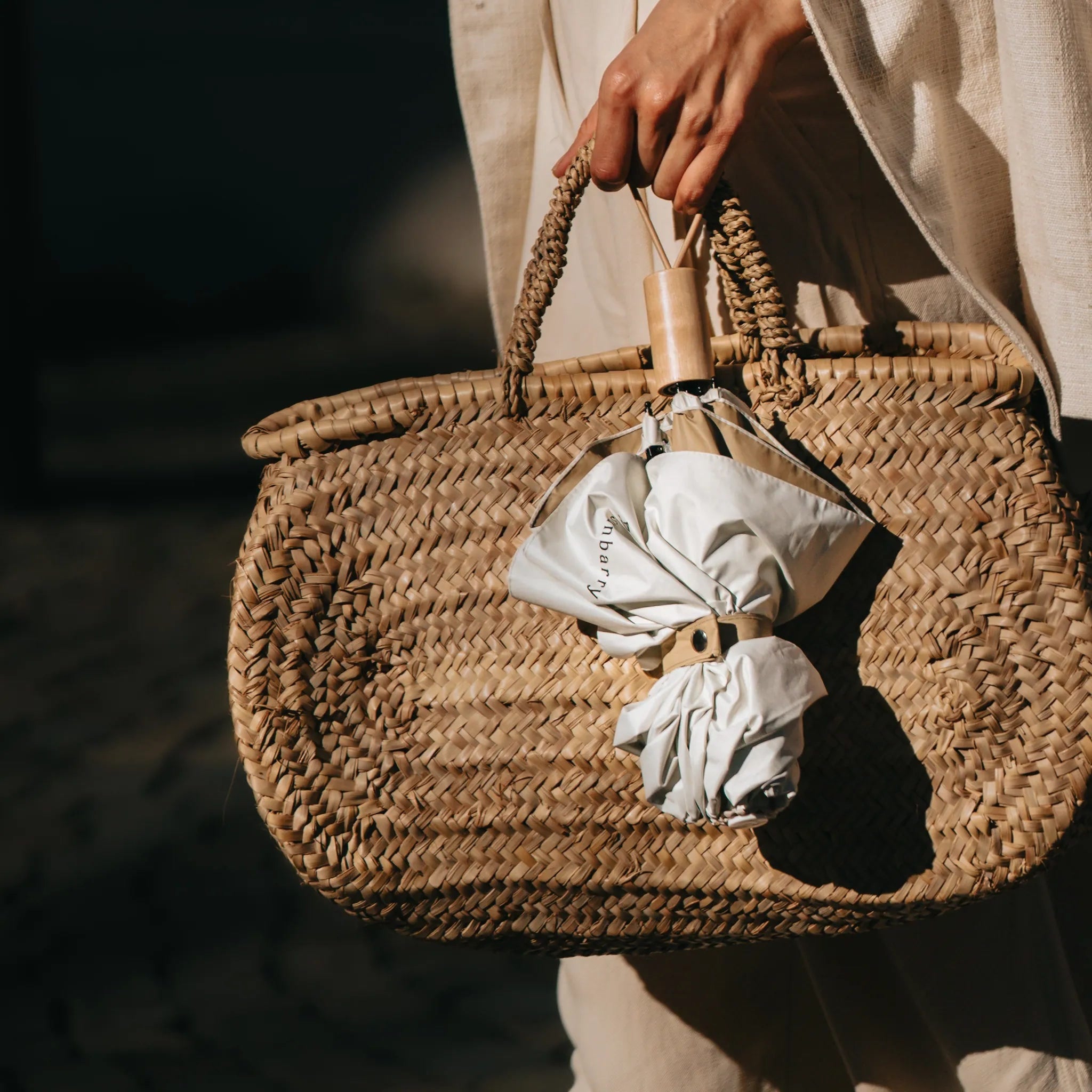 Sunbarry Cool Shader UV umbrella folded in a woven straw basket – compact parasol with wooden handle#Color_Butter & Sky